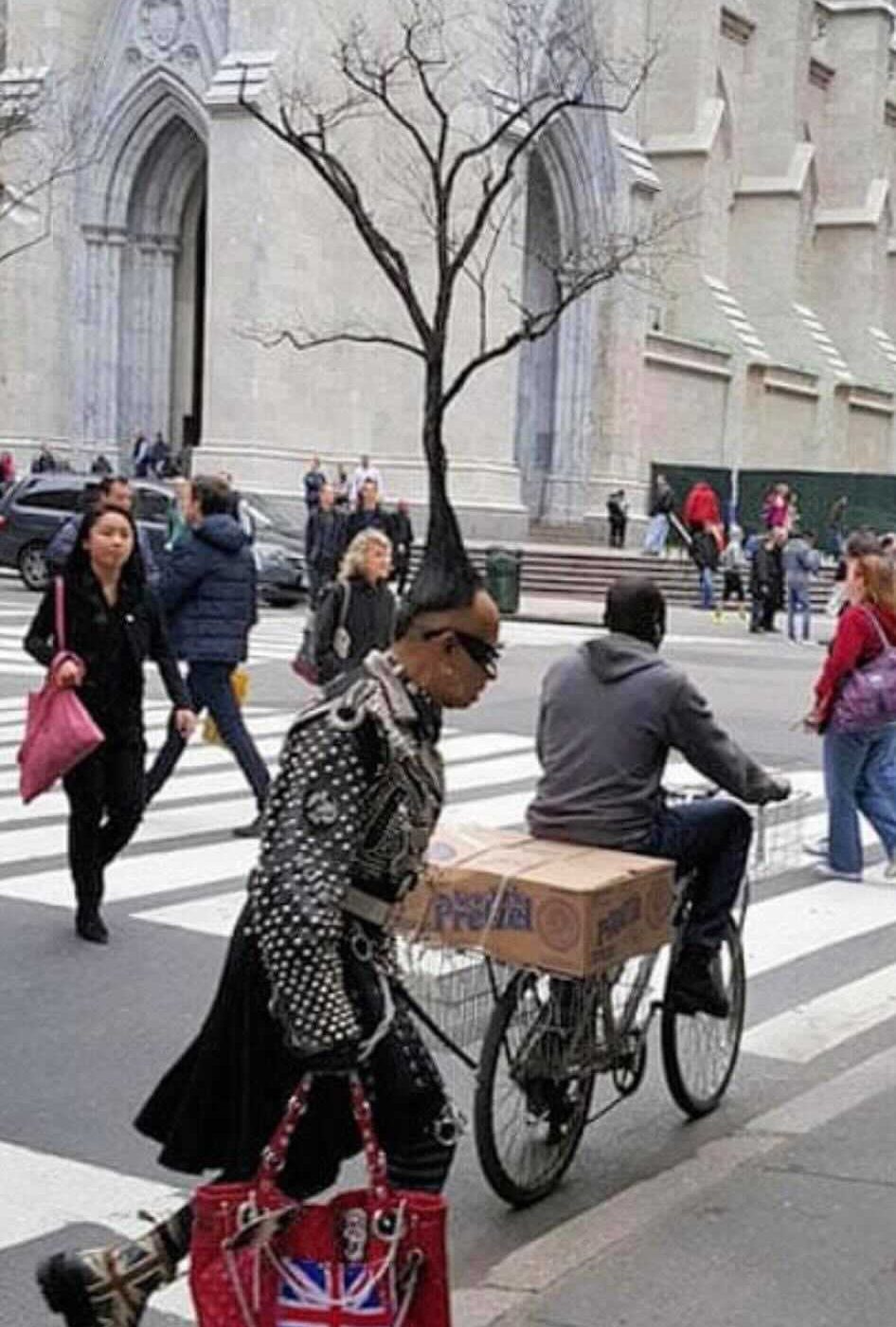 A woman carrying a Union Jack bag beside a bicycle